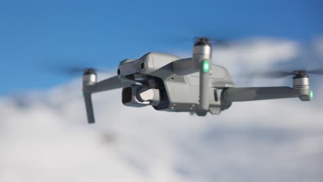 drone compacto moderno de dji air volando con montañas nevadas en el fondo