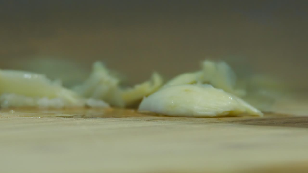 극단적 인 클로즈업: 칼이 나무 절단판에 마늘 어