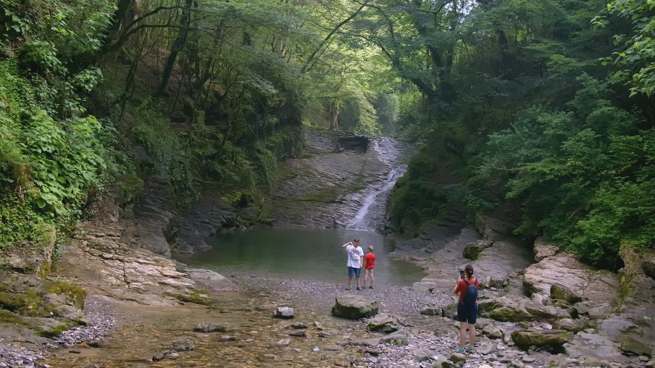 familia disfrutando de una cascada en el bosque