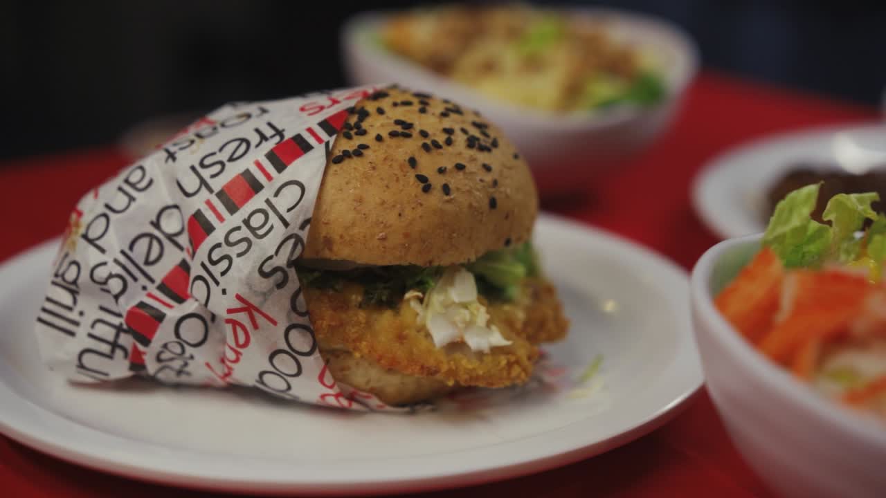 un plato de hamburguesa de pollo con guarnición de semillas de sésamo negro