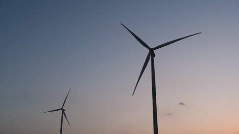 wind turbines silhouette against the blue-sky during sunset, clean alternative energy in thailand and mainland southeast asia