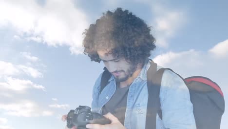 fotógrafo afroamericano haciendo clic en imágenes con una cámara digital contra las nubes en el cielo