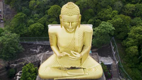 a giant golden buddha statue in lush greenery, sri lanka, captured in daytime, aerial view