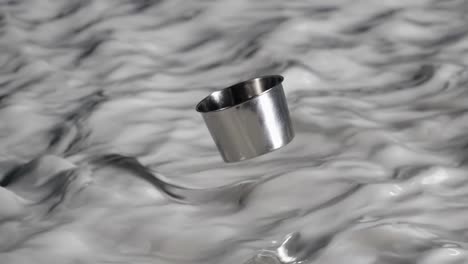 metal cup floating in milk