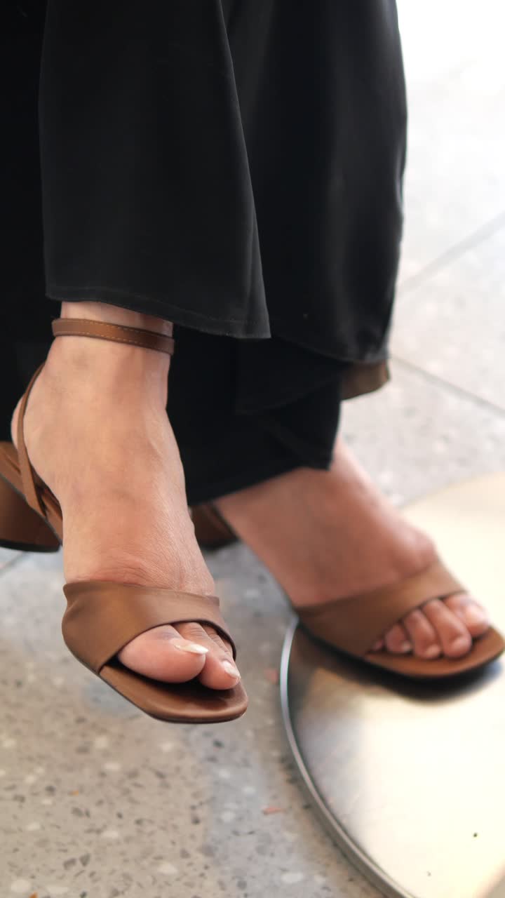 Close Up of Person's Feet Wearing Brown Sandals Indoors