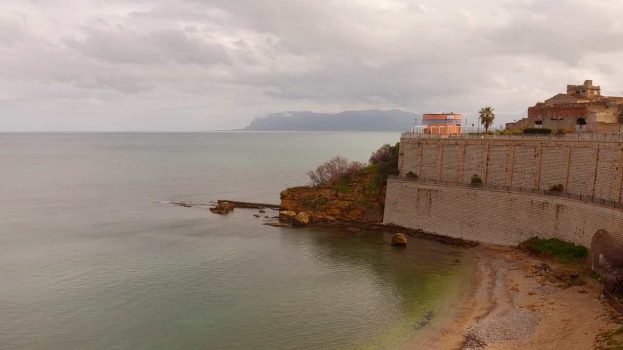 Footage of seascape with shore in foreground in Castellammare del Golfo, Sicily, Italy. Exterior architecture.