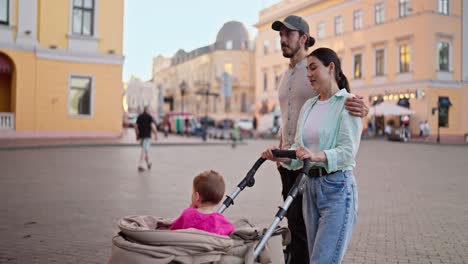 una joven familia caminando por la ciudad