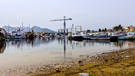 Time-lapse-low-angle-shot-of-the-gorgeous-harbor-in-sicily,-italy-with-view-of-the-floating-boats-and-the-calm-water-during-a-beautiful-trip-in-summer