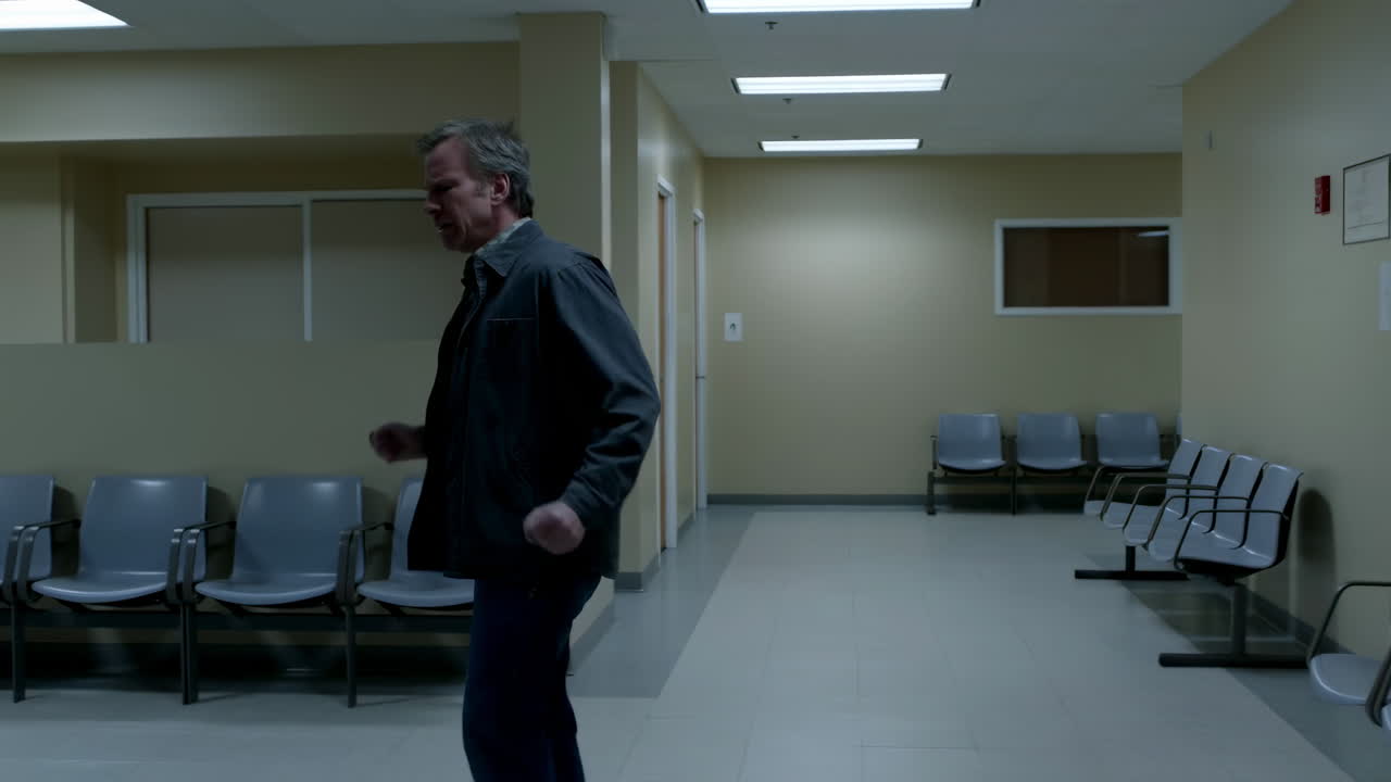 Homem de meia-idade andando ansiosamente em uma sala de espera vazia