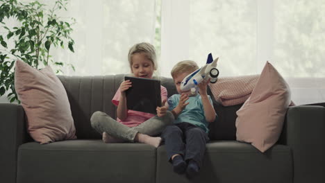 sister shows funny videos to little brother turning tablet