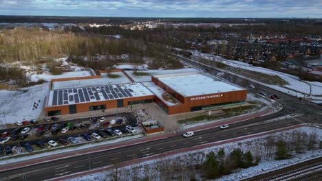 Indoor swimming pool with solar panels surrounded by snow and suburban homes in Falkensee Germany. Beautiful aerial view flight drone camera pointing down