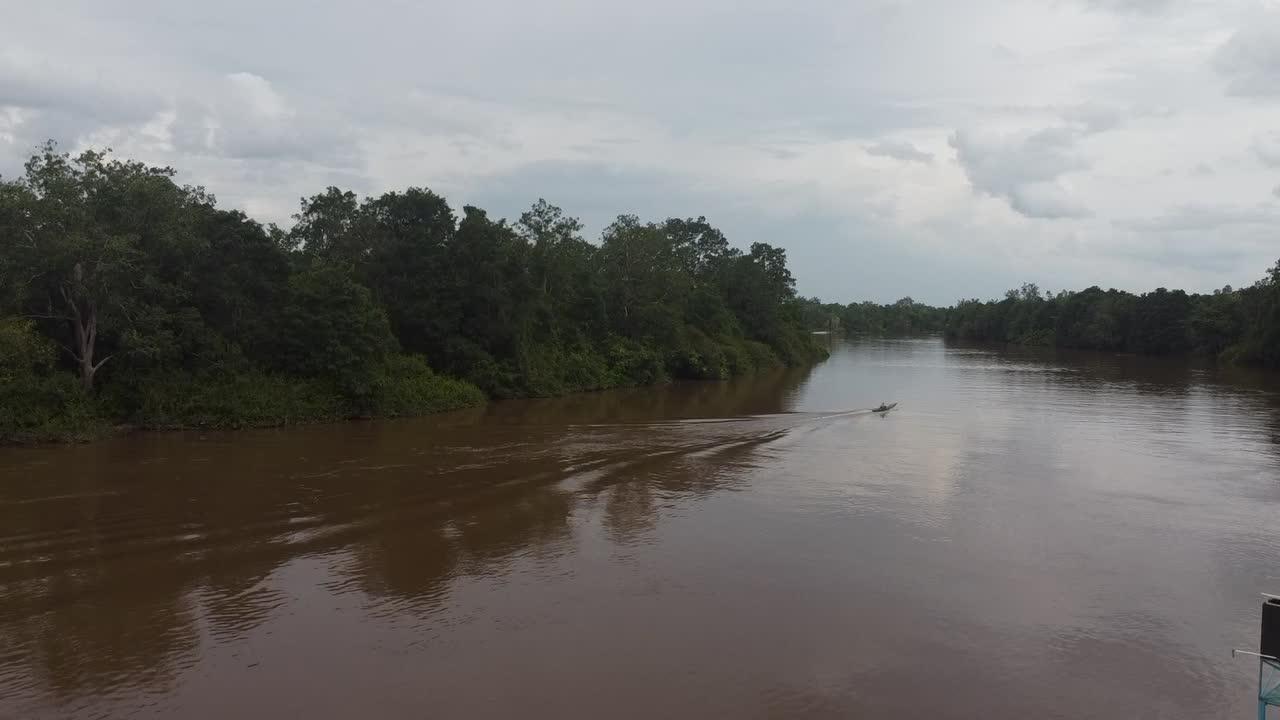 vista aérea de una lancha rápida que se aleja lentamente hacia el horizonte en medio del río