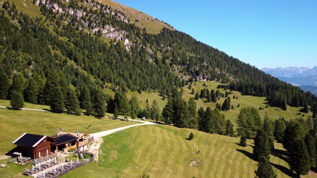 hermosa vista aérea de la cabaña de madera rústica en la cima de la colina y el pintoresco paisaje de la montaña