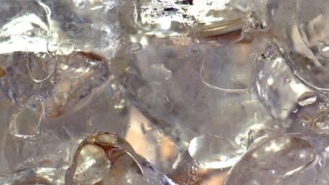 vaso lleno de cubitos de hielo que se llenan gradualmente con cerveza