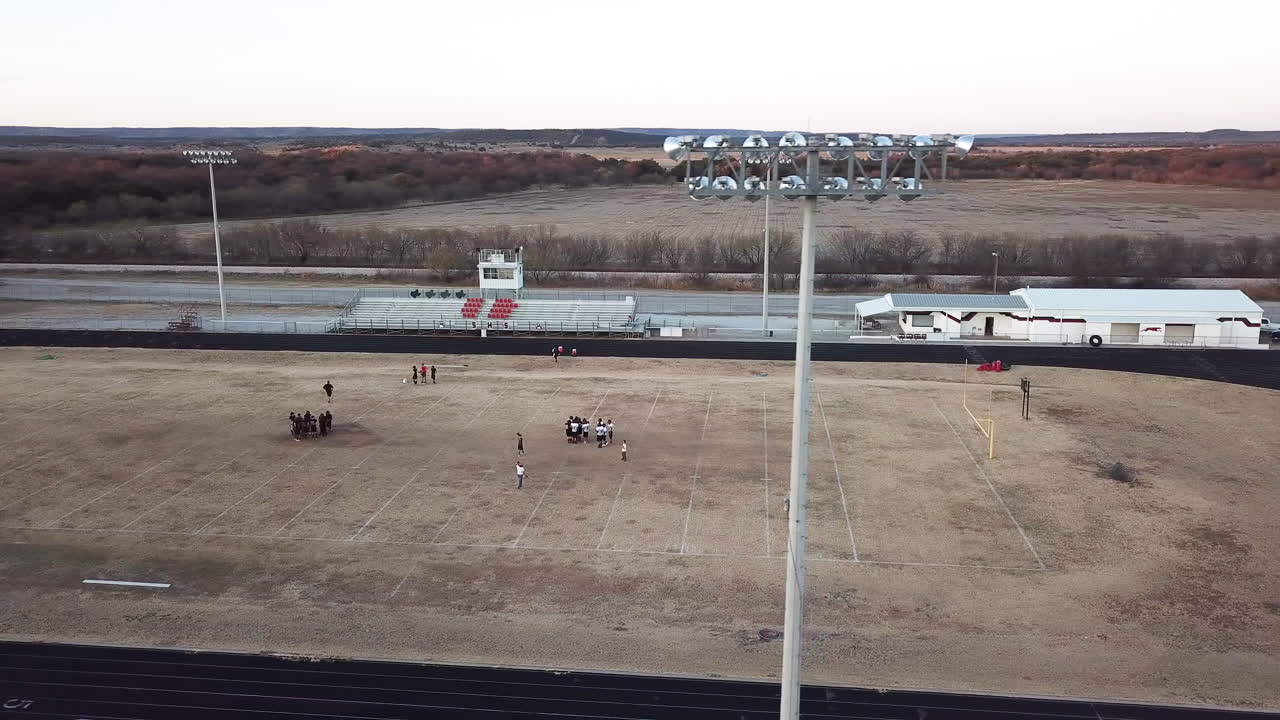 imágenes de drones del campo de fútbol de la escuela secundaria de texas durante la práctica detrás de las luces del estadio