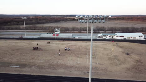 Drone-footage-of-Texas-high-school-football-field-during-practice-behind-stadium-lights