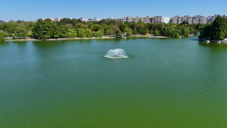 closeup aerial view of an artesian fountain in the middle of tineretului park's lake, bucharest, romania