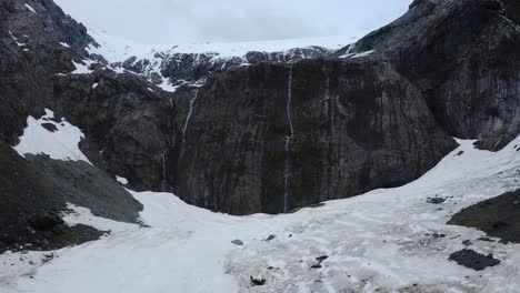 Slow-motion-dolly-in-aerial-over-a-glacier-valley-and-snowy-mountain-region-in-Fiordland,-New-Zealand,-South-Island