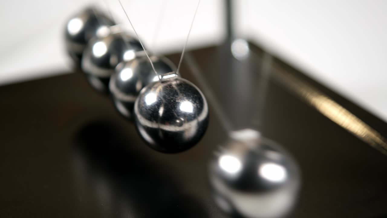 손으로 간단한 뉴턴의 요람을 태양빛에서 움직이고, 매크로, 클로즈업, 금속 공이 흔들리고, 느려지고, 무언가를 움직이고, 관성 개념, 과학, 재미, 물리학 레슨, 장난감, 실시간