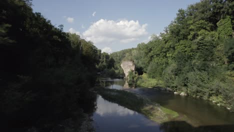 -shot: through, sam kolder
-description: drone video over the fiora river passing between a bridge very close to the water