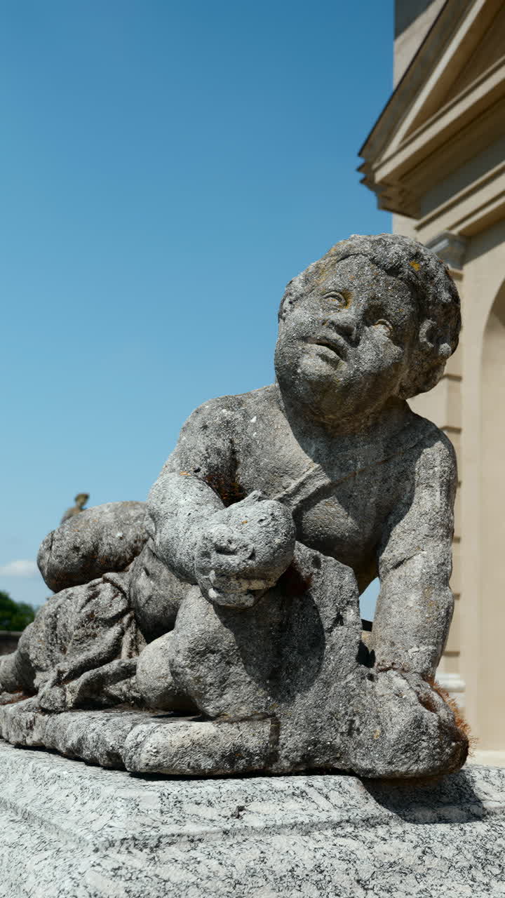 Stone statue of a cherub against a clear blue sky