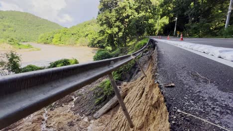 asphalt road along the river damaged by flash flood and heavy rain in chiang mai province, thailand