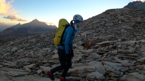 年轻女子登山者在日出时在山上徒步慢动