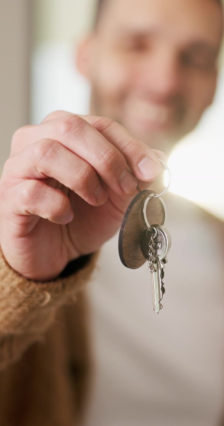 Uomo che tiene in mano le chiavi di una nuova casa