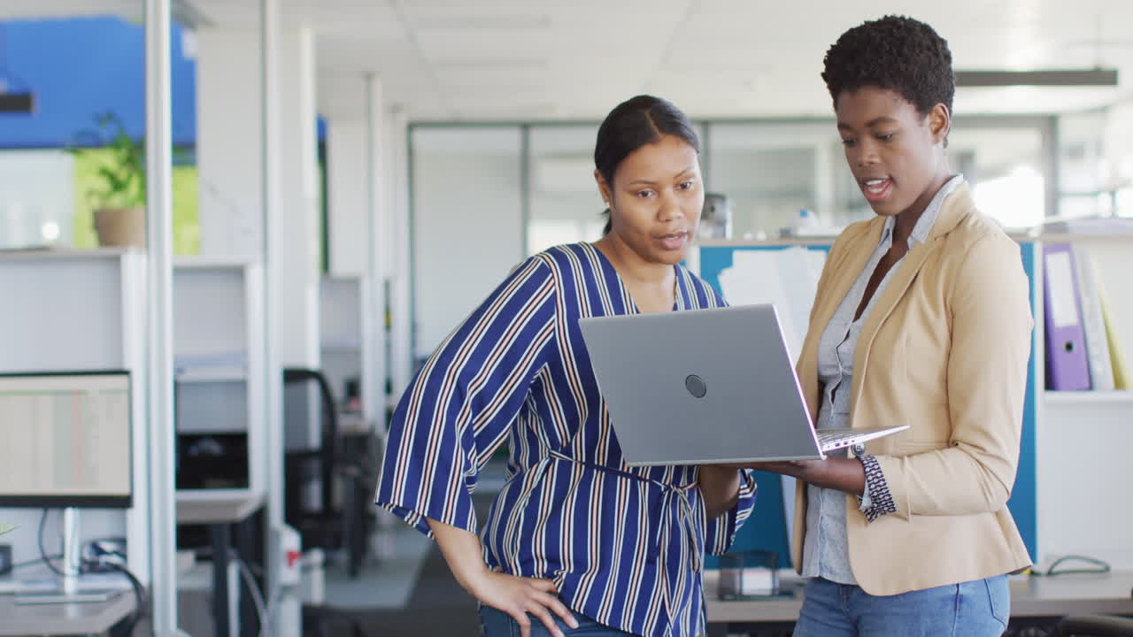 African american business people using laptop at office, slow motion