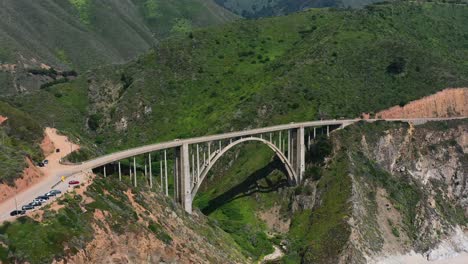 Aerial-drone-of-Bixby-Creek-Bridge-alongside-the-long-Route-1-coastal-road-of-Big-Sur-California-on-a-sunny-summer-day