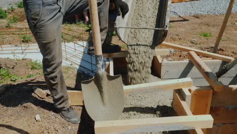 work with concrete at the construction site workers take concrete into a wooden mold heavy manual la