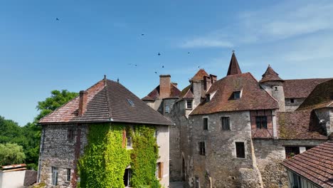 Small,-medieval-village-situated-next-to-a-river,-flowing-through-a-rich-forest-in-the-heart-of-France