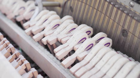 closeup of old broken piano hammers with the pedals being pressed