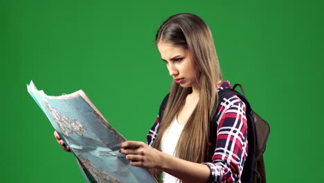 Beautiful young female tourist looking at the map with a confused expression