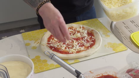 close-up of cheese being expertly spread on pizza with tomato sauce, showcasing the preparation of a classic, mouth-watering dish.