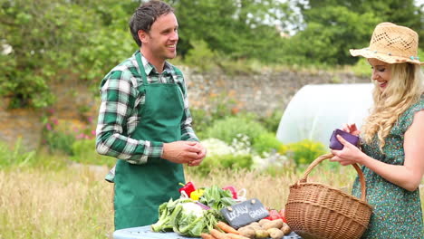 Pretty-blonde-buying-peppers-from-smiling-gardener