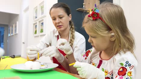 mother and daughter decorating easter eggs