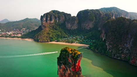 luxurious beachfront resort in krabi, thailand. drone captures an iconic limestone rock emerging from turquoise waters—perfect for nature documentaries or travel content.