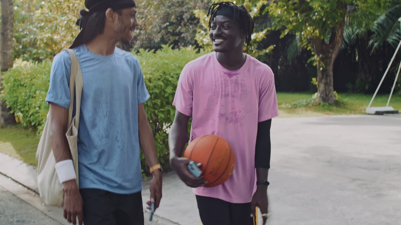 Sportsmen Checking Notification on Phone Going Home after Basketball Training