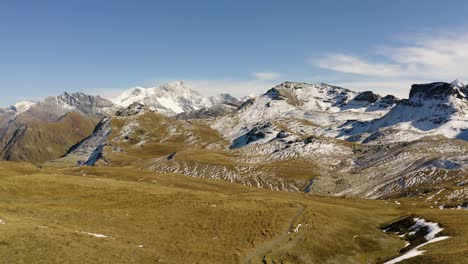 volando bajo sobre el sendero de montaña, el lago azul que aparece al final del paisaje alpino, la primera nieve y los colores del otoño