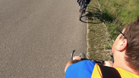 a cyclist wearing an orange vest rides his bike-2