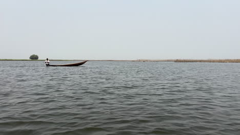 Pescador-Africano-En-Bote-En-El-Lago-Pescando-Con-Red