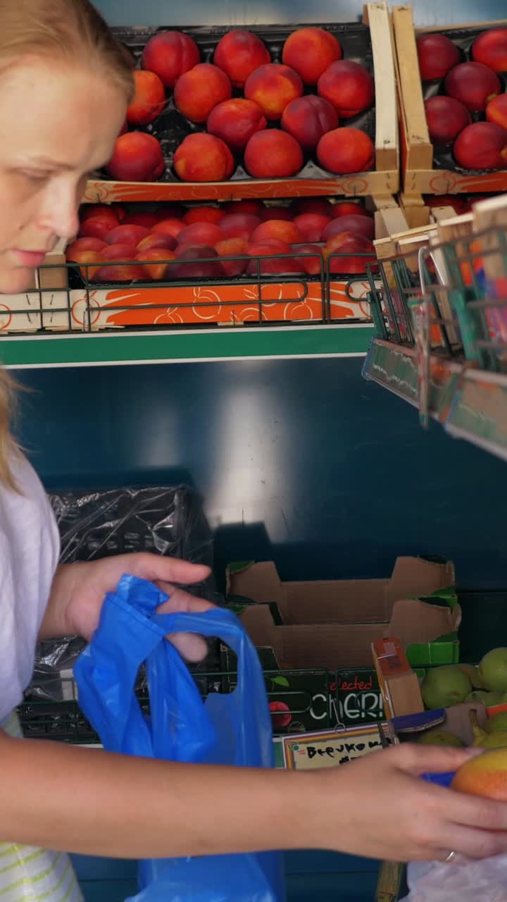 Woman shopping for peaches at the market