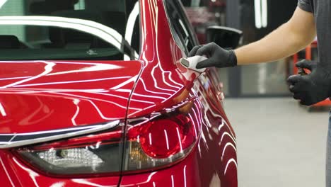 car service worker applying nano coating on a car detail.