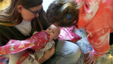 family opening christmas presents with baby