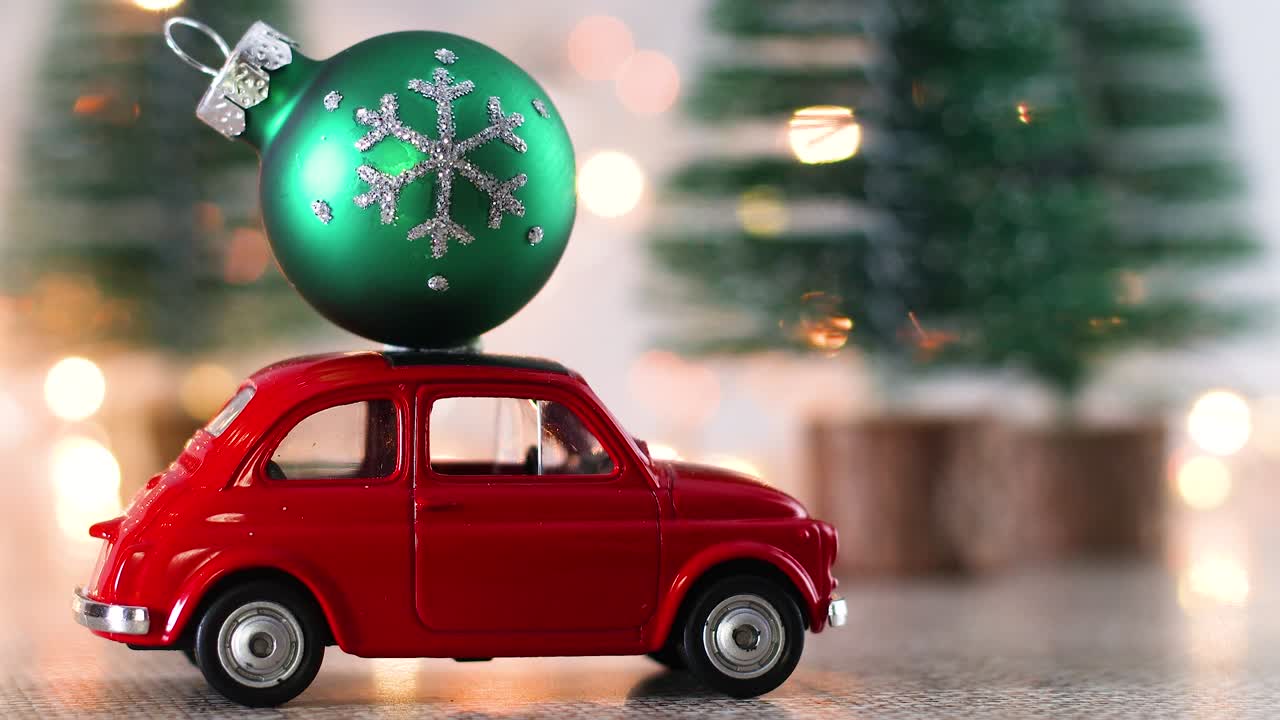Mobil kecil merah dengan ornamen Natal hijau di atap