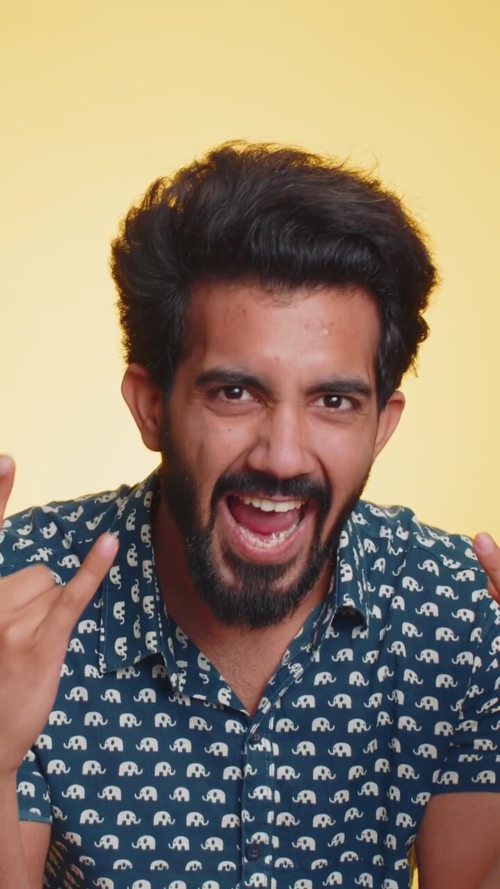 Indian man showing rock n roll gesture by hands cool sign crazy expression dancing celebrating