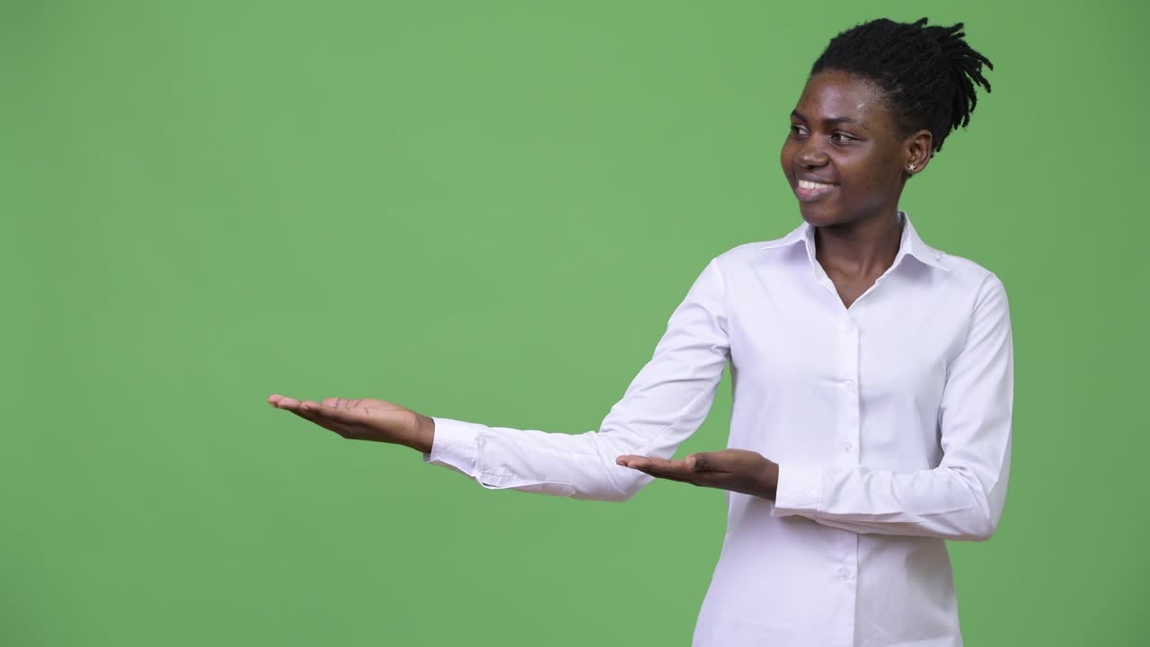Young beautiful African businesswoman showing something