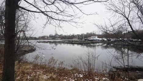 Walking-along-the-lakeshore-of-a-harbor-filled-with-boats-on-a-cold-winter-day-in-Hamilton