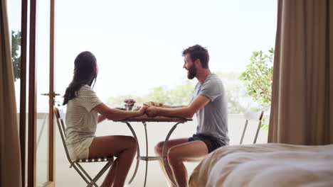 couple eating breakfast on balcony on holiday